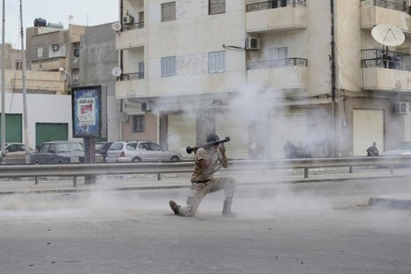 A member of the Libyan army with a weapon is seen amidst smoke during clashes between members of Islamist militant group Ansar al-Sharia and A member of the Libyan army with a weapon is seen amidst smoke during clashes between members of Islamist militant group Ansar al-Sharia and