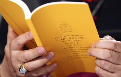 The document of the Evangelii Gaudium (The Joy of the Gospel) from Pope Francis is seen as Bishop Carlo Maria Celli reads during a presentat The document of the Evangelii Gaudium (The Joy of the Gospel) from Pope Francis is seen as Bishop Carlo Maria Celli reads during a presentat