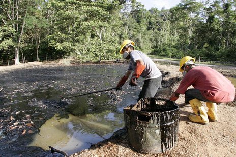 Oil workers clean up a contaminated pool in Taracoa December 10, 2007. REUTERS/Guillermo Granja Oil workers clean up a contaminated pool in Taracoa December 10, 2007. REUTERS/Guillermo Granja