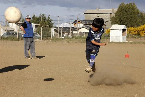 Claudio Nancufil (R) kicks the ball at the Club Martin Guemes in the Patagonian Argentine city of Bariloche November 26, 2013. REUTERS/Chiwi Claudio Nancufil (R) kicks the ball at the Club Martin Guemes in the Patagonian Argentine city of Bariloche November 26, 2013. REUTERS/Chiwi