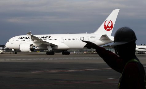 A staff of Japan Airlines' (JAL) walks past one of the company's Boeing Co's 787 Dreamliner plane at Narita international airport in Narita, A staff of Japan Airlines' (JAL) walks past one of the company's Boeing Co's 787 Dreamliner plane at Narita international airport in Narita,