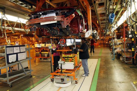 General Motors assembly workers Monique Watson (L) and Evetta Osborne install an electric battery on the underside of a 2011 Chevrolet Volt General Motors assembly workers Monique Watson (L) and Evetta Osborne install an electric battery on the underside of a 2011 Chevrolet Volt