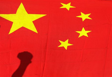 A shadow of the clenched fist of a protester is seen on a Chinese national flag during an anti-Japan protest outside the Japanese embassy in A shadow of the clenched fist of a protester is seen on a Chinese national flag during an anti-Japan protest outside the Japanese embassy in