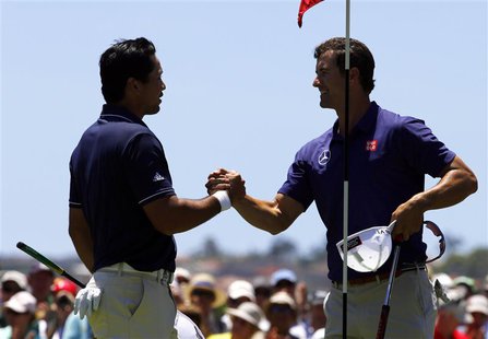 Australia's Adam Scott (R) shakes hands with playing partner and fellow countryman Jason Day after they finished their first rounds of the A Australia's Adam Scott (R) shakes hands with playing partner and fellow countryman Jason Day after they finished their first rounds of the A