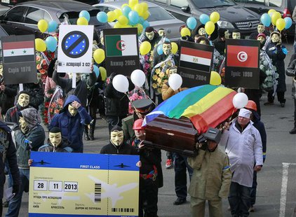 People dressed in outfits of various popular professions in Ukraine carry a coffin symbolising Ukraine's Euro-association and an airplane ti People dressed in outfits of various popular professions in Ukraine carry a coffin symbolising Ukraine's Euro-association and an airplane ti