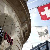 A Swiss national flag (top) and a flag of the city of Basel fly over the entrance of a branch office of Swiss bank UBS in Basel October 22, A Swiss national flag (top) and a flag of the city of Basel fly over the entrance of a branch office of Swiss bank UBS in Basel October 22,