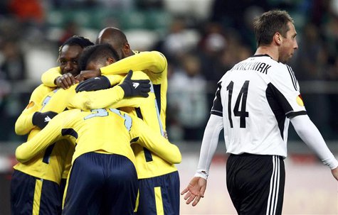 Lazio's players celebrate the goal of Felipe Anderson (unseen) as Jakub Wawrzyniak of Legia Warsaw (R) reacts during their Europa League soc Lazio's players celebrate the goal of Felipe Anderson (unseen) as Jakub Wawrzyniak of Legia Warsaw (R) reacts during their Europa League soc