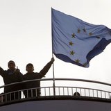 Protesters gesture as they stand near an EU flag during a demonstration in support of EU integration at Independence Square in Kiev November Protesters gesture as they stand near an EU flag during a demonstration in support of EU integration at Independence Square in Kiev November