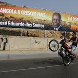 A motorcyclist rides past an election poster of the ruling MPLA party with the picture of President Jose Eduardo dos Santos in the capital L A motorcyclist rides past an election poster of the ruling MPLA party with the picture of President Jose Eduardo dos Santos in the capital L
