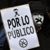 A protestor wears a mask with black tape over the mouth during a demonstration against government austerity measures and the passing of a ne A protestor wears a mask with black tape over the mouth during a demonstration against government austerity measures and the passing of a ne