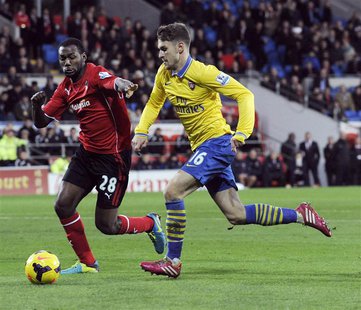 Cardiff City's Kevin Theophile-Catherine (L) challenges Arsenal's Aaron Ramsey during their English Premier League soccer match at Cardiff C Cardiff City's Kevin Theophile-Catherine (L) challenges Arsenal's Aaron Ramsey during their English Premier League soccer match at Cardiff C