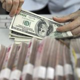 A clerk counts U.S. dollar banknotes after counting Chinese 100 Yuan banknotes at a branch of the Agricultural Bank of China in Qionghai, Ch A clerk counts U.S. dollar banknotes after counting Chinese 100 Yuan banknotes at a branch of the Agricultural Bank of China in Qionghai, Ch