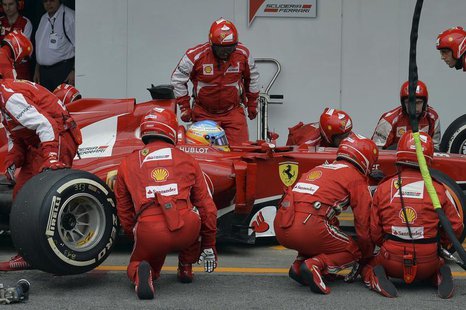 Ferrari Formula One driver Fernando Alonso of Spain is attended to by his crew during a pit stop during the Brazilian F1 Grand Prix at the I Ferrari Formula One driver Fernando Alonso of Spain is attended to by his crew during a pit stop during the Brazilian F1 Grand Prix at the I