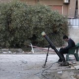 A Free Syrian Army fighter listens to music as he sits beside a rocket launcher, on a damaged street in the Jobar neighbourhood of Damascus A Free Syrian Army fighter listens to music as he sits beside a rocket launcher, on a damaged street in the Jobar neighbourhood of Damascus