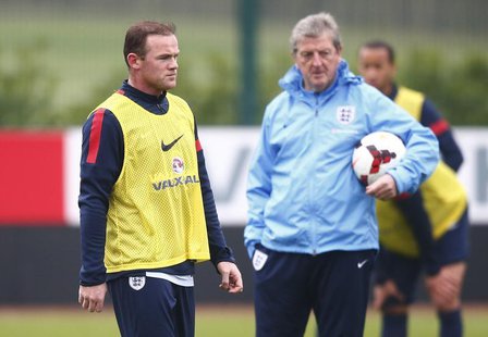England national team soccer player Wayne Rooney (L) walks past manager Roy Hodgson during a team training session at Arsenal's training fac England national team soccer player Wayne Rooney (L) walks past manager Roy Hodgson during a team training session at Arsenal's training fac