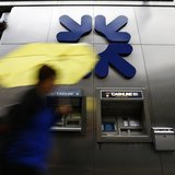 A woman shelters under an umbrella as she walks past a branch of the Royal Bank of Scotland in the City of London August 2, 2013. REUTERS/An A woman shelters under an umbrella as she walks past a branch of the Royal Bank of Scotland in the City of London August 2, 2013. REUTERS/An