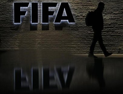 A man is silhouetted as he makes his way past the main entrance of FIFA headquarters, the Home of FIFA, in Zurich October 20, 2010. REUTERS/ A man is silhouetted as he makes his way past the main entrance of FIFA headquarters, the Home of FIFA, in Zurich October 20, 2010. REUTERS/