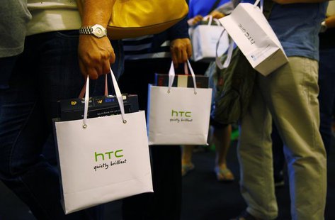Customers hold bags containing their HTC One mobile phone purchases during the first day of public sales at Taman Anggrek Mall in Jakarta, J Customers hold bags containing their HTC One mobile phone purchases during the first day of public sales at Taman Anggrek Mall in Jakarta, J