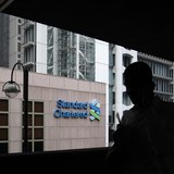 A man walks on a footbridge connected to the Standard Chartered headquarters in Hong Kong August 7, 2012. REUTERS/Bobby Yip A man walks on a footbridge connected to the Standard Chartered headquarters in Hong Kong August 7, 2012. REUTERS/Bobby Yip