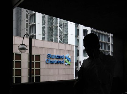 A man walks on a footbridge connected to the Standard Chartered headquarters in Hong Kong August 7, 2012. REUTERS/Bobby Yip A man walks on a footbridge connected to the Standard Chartered headquarters in Hong Kong August 7, 2012. REUTERS/Bobby Yip