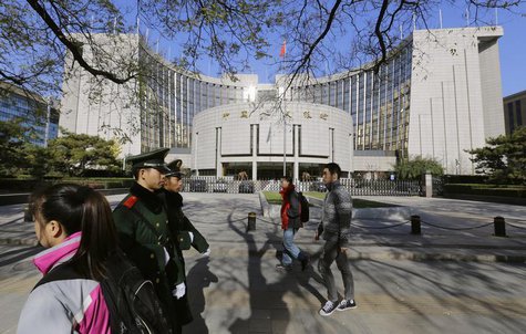 People walk past the headquarters of the People's Bank of China (PBOC), the central bank, as two paramilitary police officials patrol around People walk past the headquarters of the People's Bank of China (PBOC), the central bank, as two paramilitary police officials patrol around