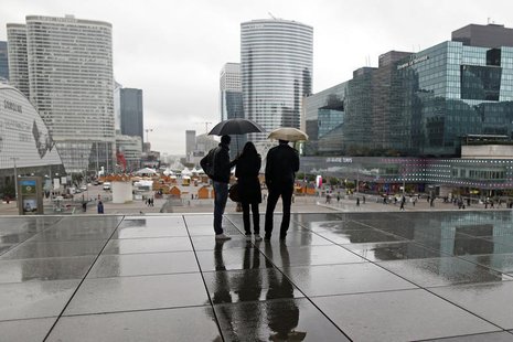People are silhouetted as they shelter from rain under the Arche de la Defense, in the financial district west of Paris, November 8, 2013. R People are silhouetted as they shelter from rain under the Arche de la Defense, in the financial district west of Paris, November 8, 2013. R