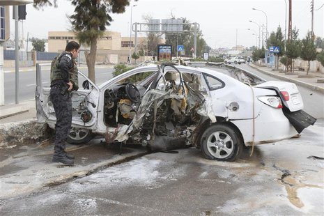 An Iraqi security forces personnel inspects a car after a bomb in Kirkuk, 250 km (155 miles) north of Baghdad, December 4, 2013. REUTERS/Ako An Iraqi security forces personnel inspects a car after a bomb in Kirkuk, 250 km (155 miles) north of Baghdad, December 4, 2013. REUTERS/Ako