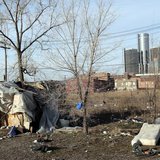 A makeshift homeless persons structure is seen, with General Motors Corp. world headquarters headquarters in the background, from an mostly A makeshift homeless persons structure is seen, with General Motors Corp. world headquarters headquarters in the background, from an mostly