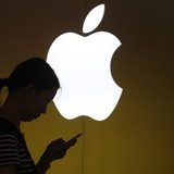 A woman looks at the screen of her mobile phone in front of an Apple logo outside its store in downtown Shanghai September 10, 2013. REUTERS A woman looks at the screen of her mobile phone in front of an Apple logo outside its store in downtown Shanghai September 10, 2013. REUTERS