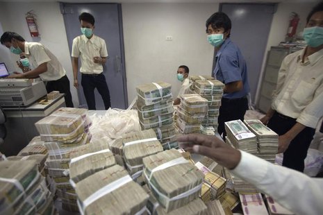 Employees count and pack money inside a bank in Yangon November 14, 2013. REUTERS/Minzayar Employees count and pack money inside a bank in Yangon November 14, 2013. REUTERS/Minzayar
