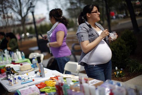 Karen Giral, 20, works at her booth selling Avon products at a Grameen America open house at St. John's University in New York April 18, 200 Karen Giral, 20, works at her booth selling Avon products at a Grameen America open house at St. John's University in New York April 18, 200