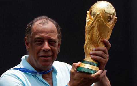 Former Brazilian soccer captain Carlos Alberto Torres holds the 2014 FIFA World Cup Brazil trophy during its unveiling ceremony at a Soccere Former Brazilian soccer captain Carlos Alberto Torres holds the 2014 FIFA World Cup Brazil trophy during its unveiling ceremony at a Soccere