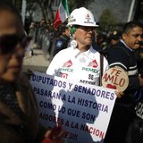 A demonstrator holds a placard while arriving to a protest against the energy reform outside the Senate building in Mexico City December 4, A demonstrator holds a placard while arriving to a protest against the energy reform outside the Senate building in Mexico City December 4,