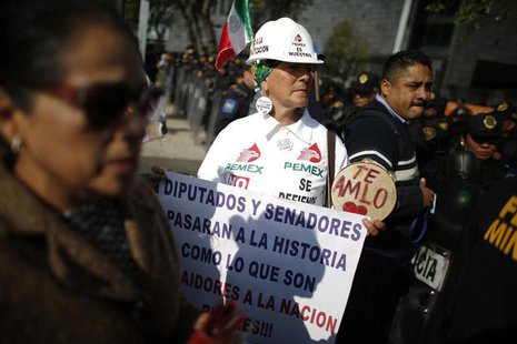 A demonstrator holds a placard while arriving to a protest against the energy reform outside the Senate building in Mexico City December 4, A demonstrator holds a placard while arriving to a protest against the energy reform outside the Senate building in Mexico City December 4,
