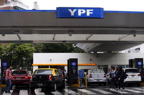 People walk past a YPF petrol station in Buenos Aires November 26, 2013. REUTERS/Marcos Brindicci People walk past a YPF petrol station in Buenos Aires November 26, 2013. REUTERS/Marcos Brindicci