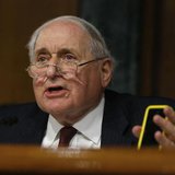 Senate homeland security and governmental affairs investigations subcommittee Chairman Carl Levin (D-MI) holds an iPhone as he speaks to App Senate homeland security and governmental affairs investigations subcommittee Chairman Carl Levin (D-MI) holds an iPhone as he speaks to App