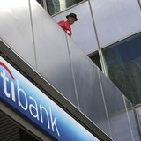 A man watches police officers make arrests as protesters from political activist group 99 Rise stage a sit-in at the entrance of a CitiBank A man watches police officers make arrests as protesters from political activist group 99 Rise stage a sit-in at the entrance of a CitiBank