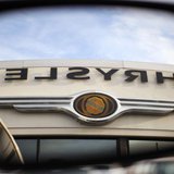 The Chrysler logo is reflected in the rear view mirror of a vehicle on the lot at Clark Chrysler Jeep Dodge dealership in Methuen, Massachus The Chrysler logo is reflected in the rear view mirror of a vehicle on the lot at Clark Chrysler Jeep Dodge dealership in Methuen, Massachus