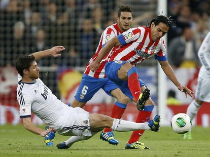 Real Madrid's Xabi Alonso (L) challenges Atletico Madrid's Radamel Falcao during their Spanish King's Cup final soccer match at Santiago Ber Real Madrid's Xabi Alonso (L) challenges Atletico Madrid's Radamel Falcao during their Spanish King's Cup final soccer match at Santiago Ber