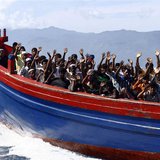 Ethnic Rohingya refugees from Myanmar wave as they are transported by a wooden boat to a temporary shelter in Krueng Raya in Aceh Besar, in Ethnic Rohingya refugees from Myanmar wave as they are transported by a wooden boat to a temporary shelter in Krueng Raya in Aceh Besar, in