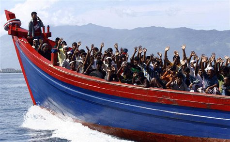 Ethnic Rohingya refugees from Myanmar wave as they are transported by a wooden boat to a temporary shelter in Krueng Raya in Aceh Besar, in Ethnic Rohingya refugees from Myanmar wave as they are transported by a wooden boat to a temporary shelter in Krueng Raya in Aceh Besar, in