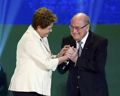 Brazilian President Dilma Rousseff (L) and FIFA President Sepp Blatter react on stage during the draw for the 2014 World Cup at the Costa do Brazilian President Dilma Rousseff (L) and FIFA President Sepp Blatter react on stage during the draw for the 2014 World Cup at the Costa do