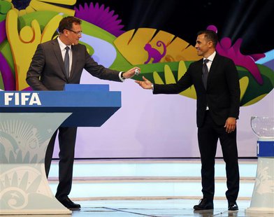 Former Italy soccer player Fabio Cannavaro (R) hands a ball that he had drawn from a pot to FIFA Secretary General Jerome Valcke during the Former Italy soccer player Fabio Cannavaro (R) hands a ball that he had drawn from a pot to FIFA Secretary General Jerome Valcke during the