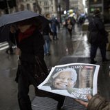 A woman distributes a newspaper featuring the late Nelson Mandela on the front page in New York, December 6, 2013. REUTERS/Brendan McDermid A woman distributes a newspaper featuring the late Nelson Mandela on the front page in New York, December 6, 2013. REUTERS/Brendan McDermid