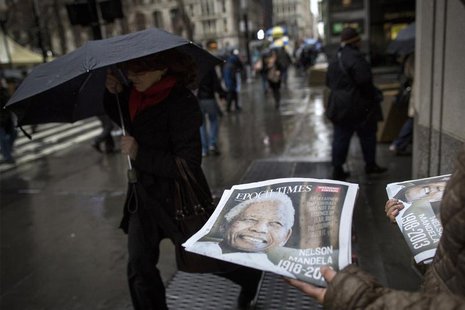 A woman distributes a newspaper featuring the late Nelson Mandela on the front page in New York, December 6, 2013. REUTERS/Brendan McDermid A woman distributes a newspaper featuring the late Nelson Mandela on the front page in New York, December 6, 2013. REUTERS/Brendan McDermid