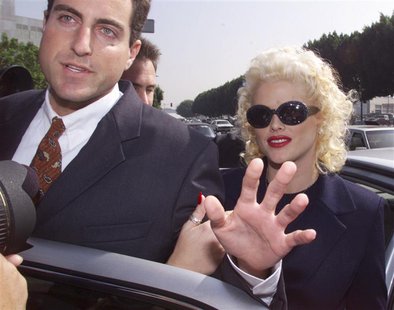 Model and former Playboy magazine Playmate Anna Nicole Smith is escorted by an unidentified attorney from her car as she arrives for opening Model and former Playboy magazine Playmate Anna Nicole Smith is escorted by an unidentified attorney from her car as she arrives for opening