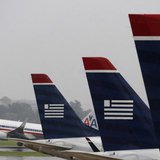 An American Airlines jet takes off while U.S. Airways jets are lined up at Reagan National Airport on the day U.S. Airways' stockholders are An American Airlines jet takes off while U.S. Airways jets are lined up at Reagan National Airport on the day U.S. Airways' stockholders are