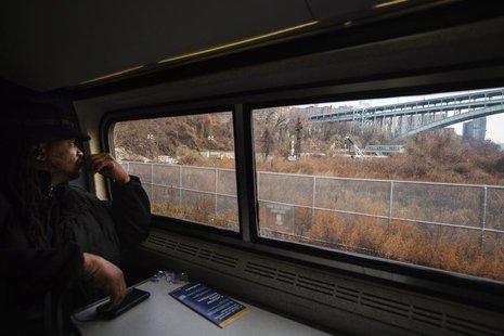 Passenger James Earl looks out of the window of an Amtrak train as it passes the site of a derailed Metro-North Railroad train in New York, Passenger James Earl looks out of the window of an Amtrak train as it passes the site of a derailed Metro-North Railroad train in New York,