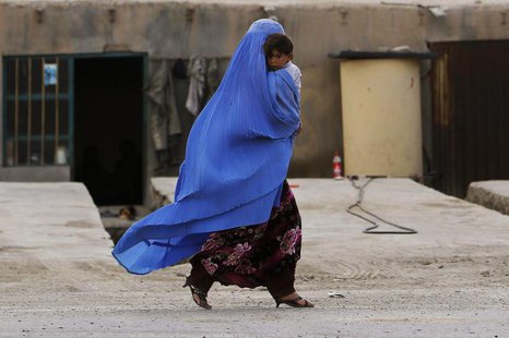 An Afghan woman wearing a burqa holds her child as she walks along a street on the outskirts of Kabul May 13, 2013. REUTERS/Omar Sobhani An Afghan woman wearing a burqa holds her child as she walks along a street on the outskirts of Kabul May 13, 2013. REUTERS/Omar Sobhani