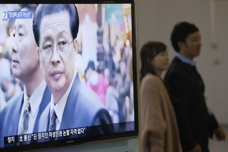 A couple walks past a television showing a report on Jang Song Thaek, North Korean leaders' uncle, at a railway station in Seoul December 3, A couple walks past a television showing a report on Jang Song Thaek, North Korean leaders' uncle, at a railway station in Seoul December 3,